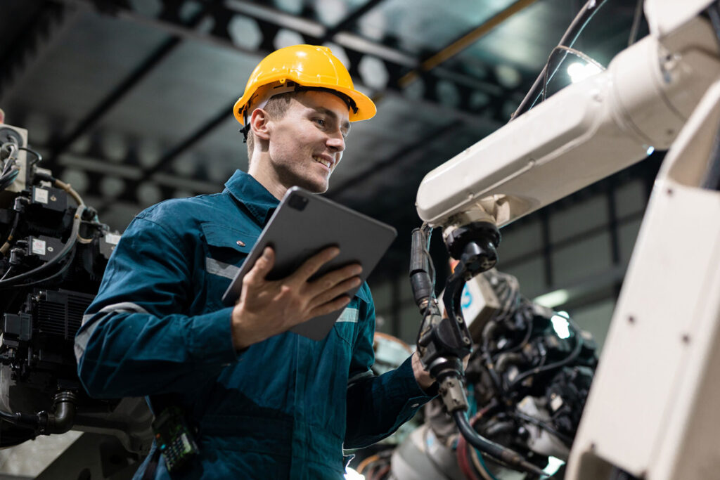 Robotic engineer automatic mechanic checking quality system of automation robot arms machine in factory. Service programming machinery welding robots in production at factory industry | ANG