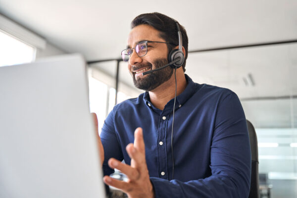 Happy-call-center-agent-wearing-headset-talking-to-client-working-in-customer-support-office.-Professional-contract-service-telemarketing-operator-using-laptop-having-conversation. Happy-call-center-agent-wearing-headset-talking-to-client-working-in-customer-support-office.-Professional-contract-service-telemarketing-operator-using-laptop-having-conversation.