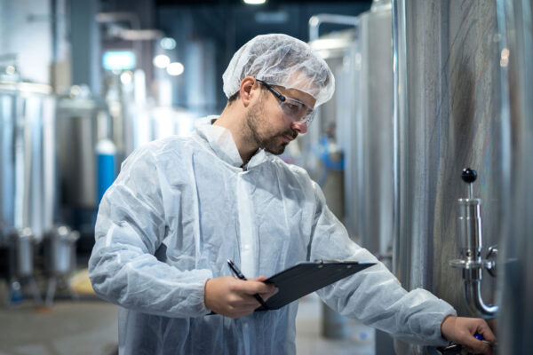 Middle-aged-concentrated-technologist-worker-controlling-production-in-pharmaceutical-or-chemical-industry. Middle-aged-concentrated-technologist-worker-controlling-production-in-pharmaceutical-or-chemical-industry.