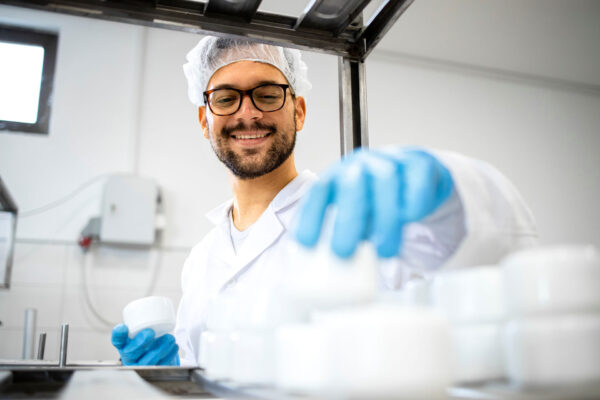 Pharma-Close-up-view-of-pharmaceutical-worker-technologist-working-in-cosmetics-factory-with-healthcare-creme-products. Pharma-Close-up-view-of-pharmaceutical-worker-technologist-working-in-cosmetics-factory-with-healthcare-creme-products.