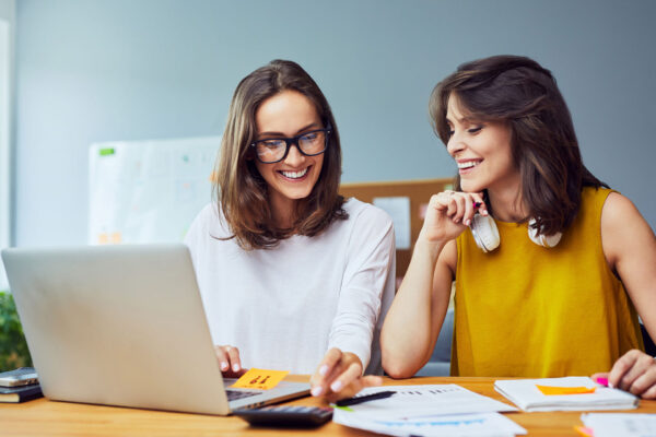 Two-young-women-working-together-at-office-planning-business