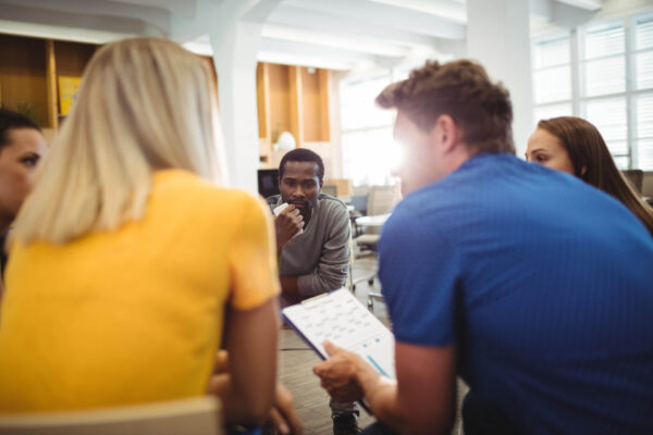 Business executives interacting with each other during meeting in office